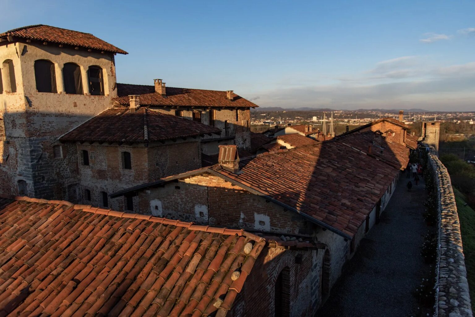 Tetti del Ricetto e catena alpina al tramonto