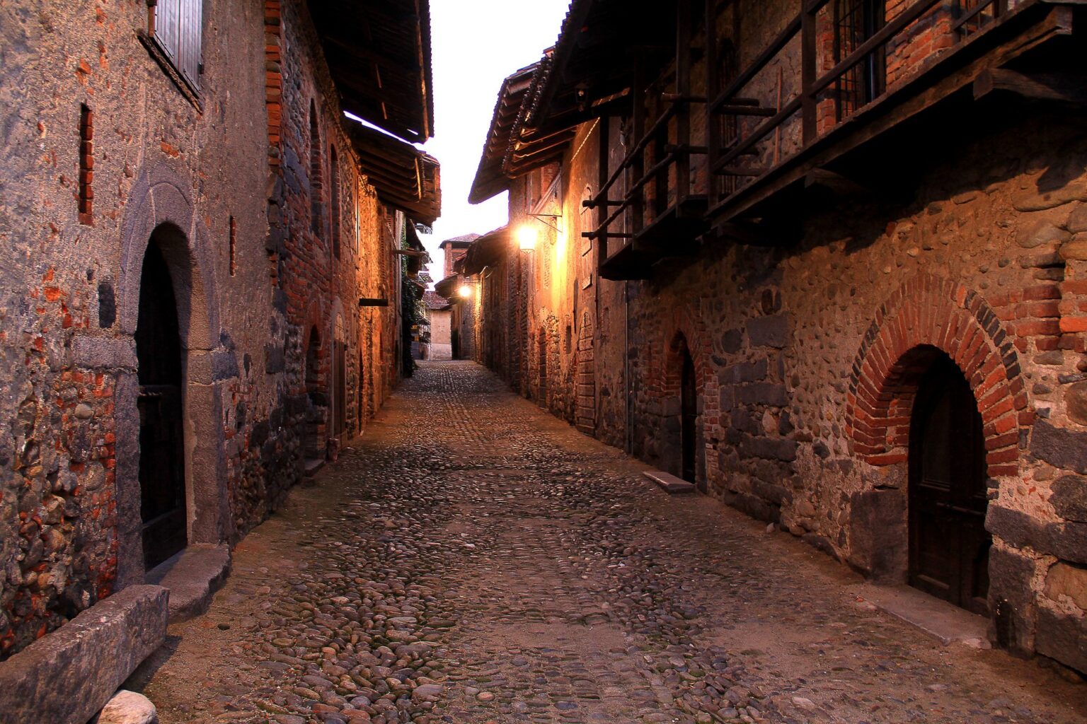 Rua del Ricetto al tramonto con le lobbie in legno